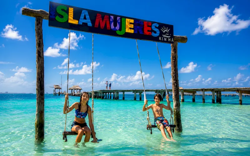 Beach swings beside turquoise water in Isla Mujeres