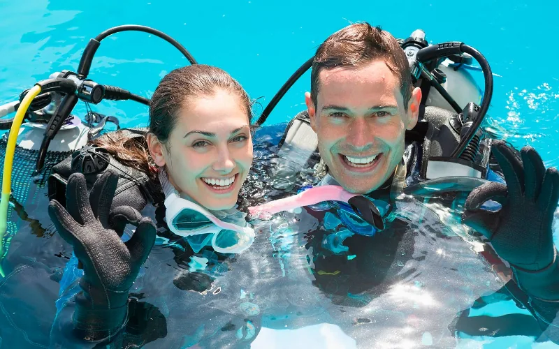 Beginner receiving professional guidance during a first scuba experience in Isla Mujeres